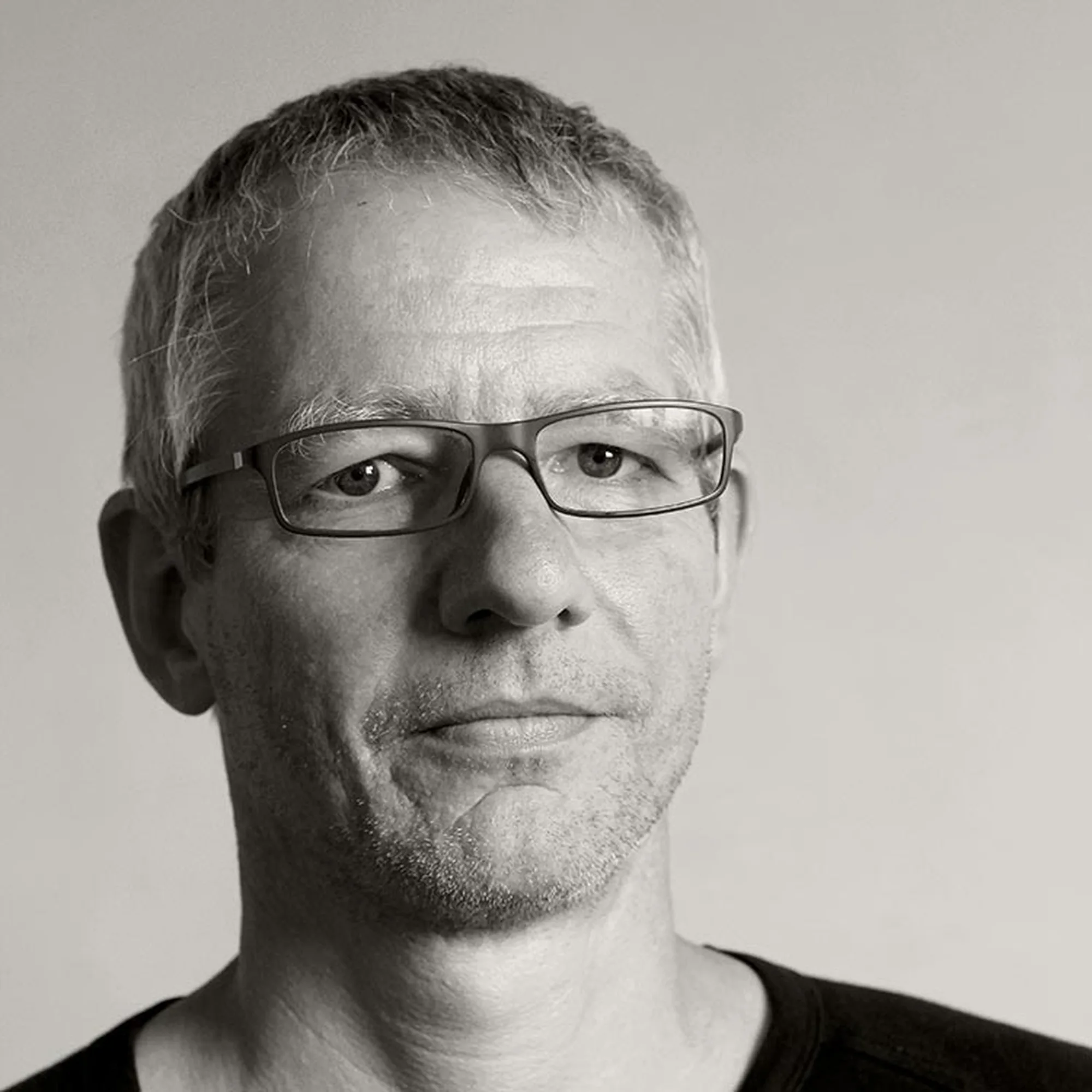 Schwarz-Weiß-Porträt des Bildhauers Matthias Eder mit Brille
