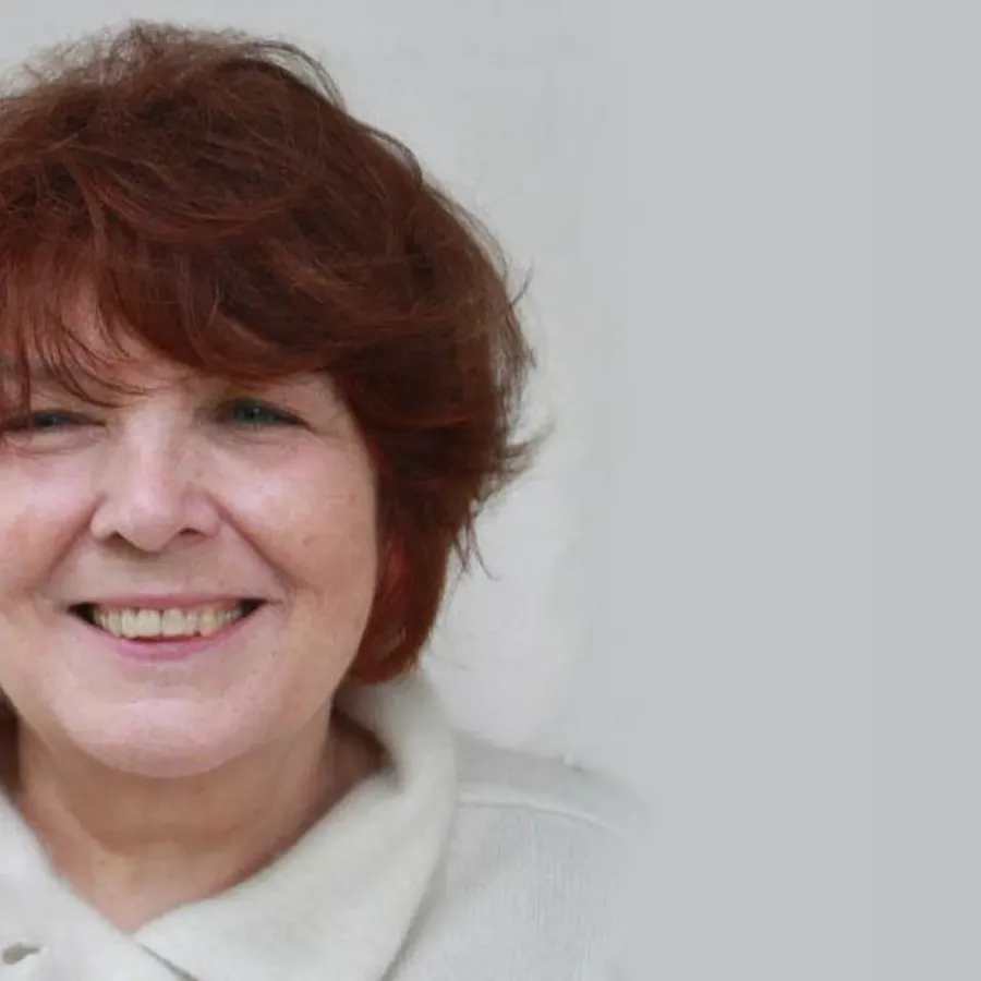 Porträt der Bildhauerin Jana Pfeifer mit kurzem rotbraunem Haar, lächelnd vor hellem Hintergrund