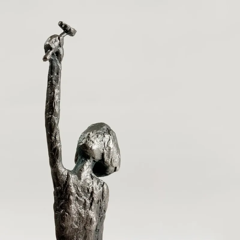 Susanne Kraißer Blumenmädchen, Nahaufnahme des Oberkörpers von schräg hinten mit erhobenem Arm und rauer Silberoberfläche